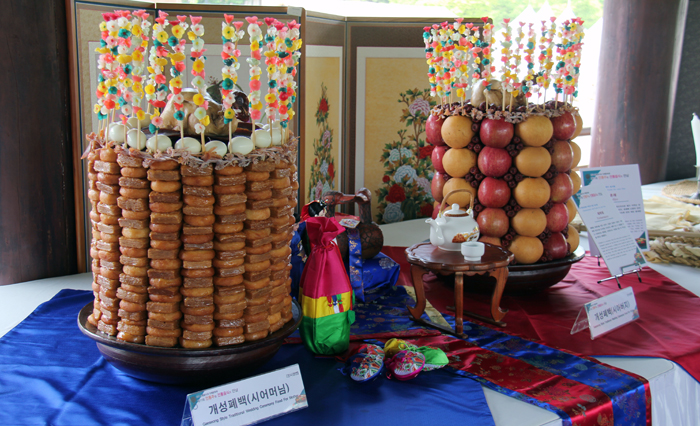 A table setting for a traditional wedding feast following traditions from the North Korean city of Gaeseong captures the attention of many visitors to the Namsangol Hanok Village in Jung-gu District, Seoul, on May 10 and 11. The photo shows a Gaeseong-style traditional wedding feast prepared for the groom’s parents, which features eggs, fried rice cakes and square-shaped honey cookies. (Lee Yoonseo)